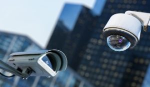 Two CCTV cameras with city building unfocused in the background